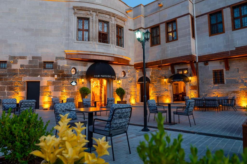 een patio met tafels en stoelen voor een gebouw bij Four Mansions Hotel in Kayseri