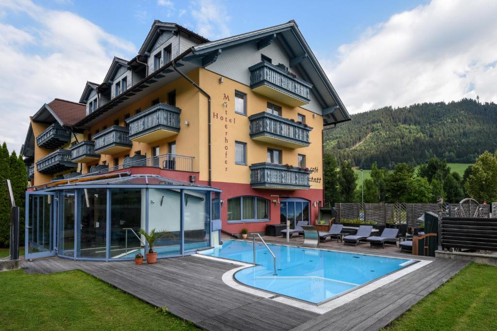 ein Hotel mit einem Pool vor einem Gebäude in der Unterkunft Alpinhotel Maistatt in Schladming