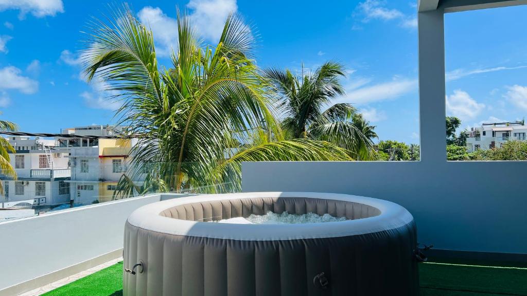 een hot tub op een balkon met een palmboom bij Blissful Villa in Grand Baie