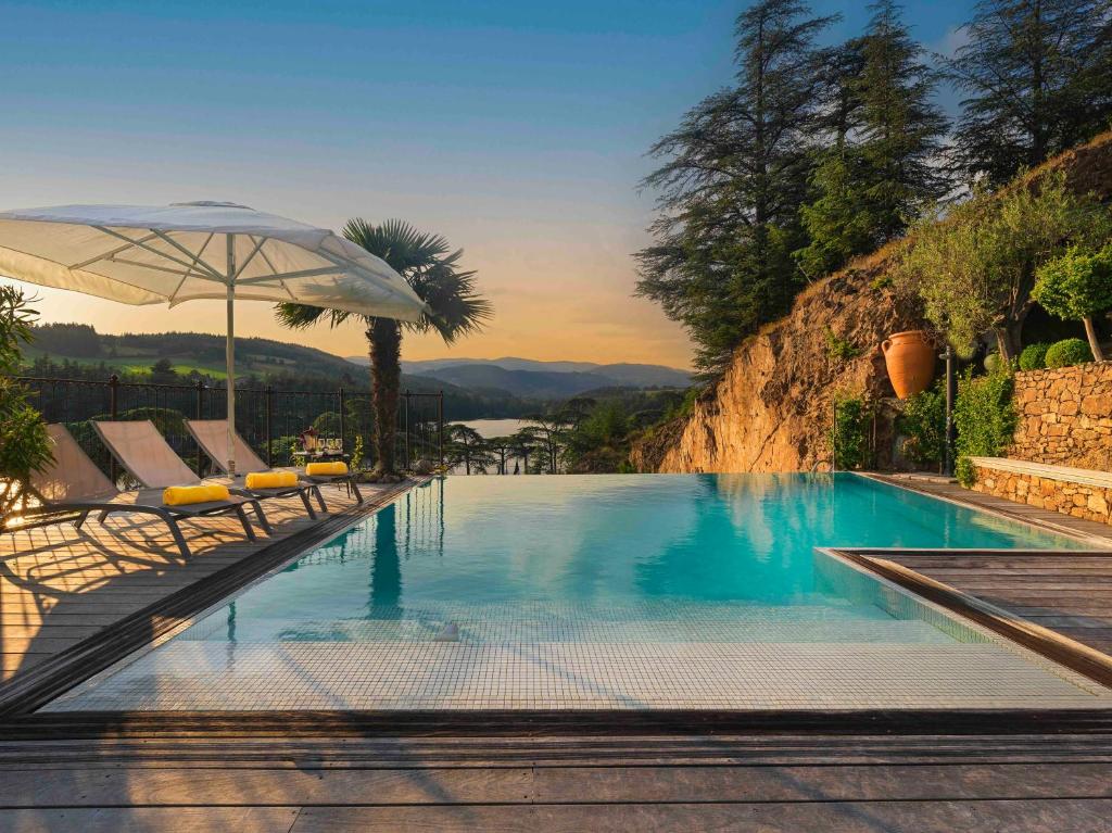 piscina con sedie e ombrellone di Auberge Du Lac a Saint-Marcel-lès-Annonay