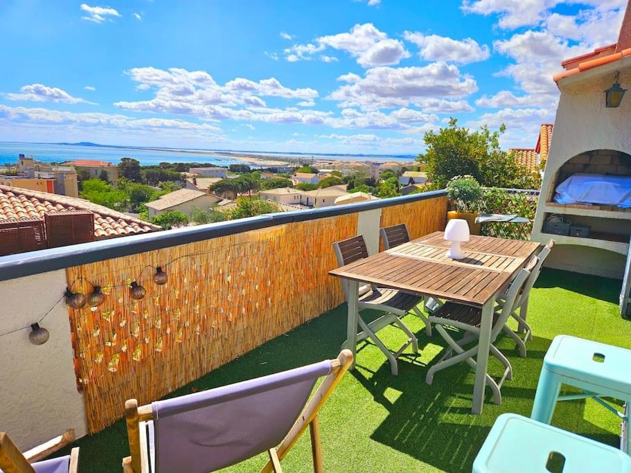 un patio con tavolo e sedie sul balcone. di Villa Farniente a Sète