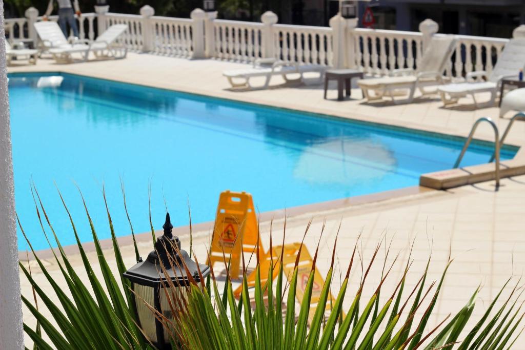 ein Pool mit Stühlen und ein gelbes Objekt daneben in der Unterkunft Letoon Homes in Oludeniz