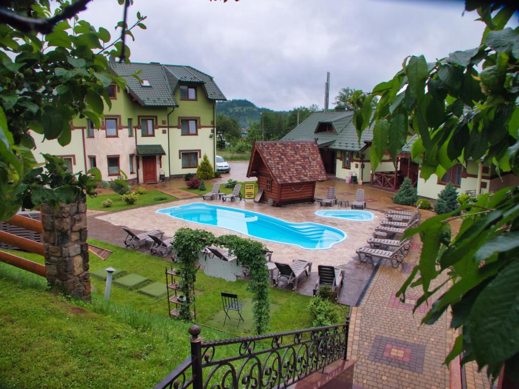 a backyard with a swimming pool and a house at Emerald House in Mykulychyn