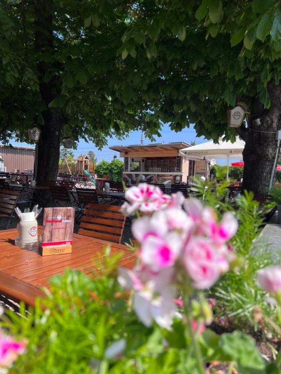 una mesa de madera con flores rosas encima en Gasthaus & Hotel Backhendlstation, en Enns