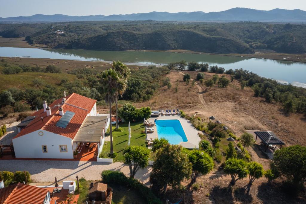 una vista aerea di una casa con piscina e lago di Monte Do Zambujeiro a Vila Nova de Milfontes