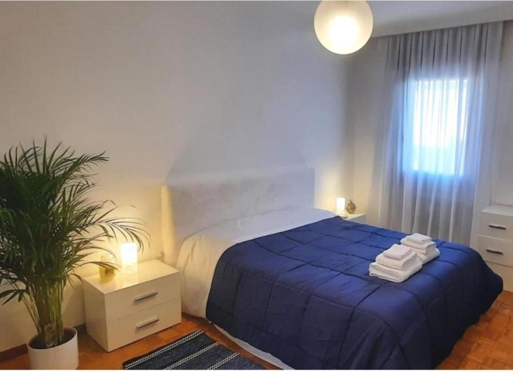 een slaapkamer met een blauw bed en handdoeken bij Verdisuite - Trento centro - Parcheggio privato gratuito in Trento