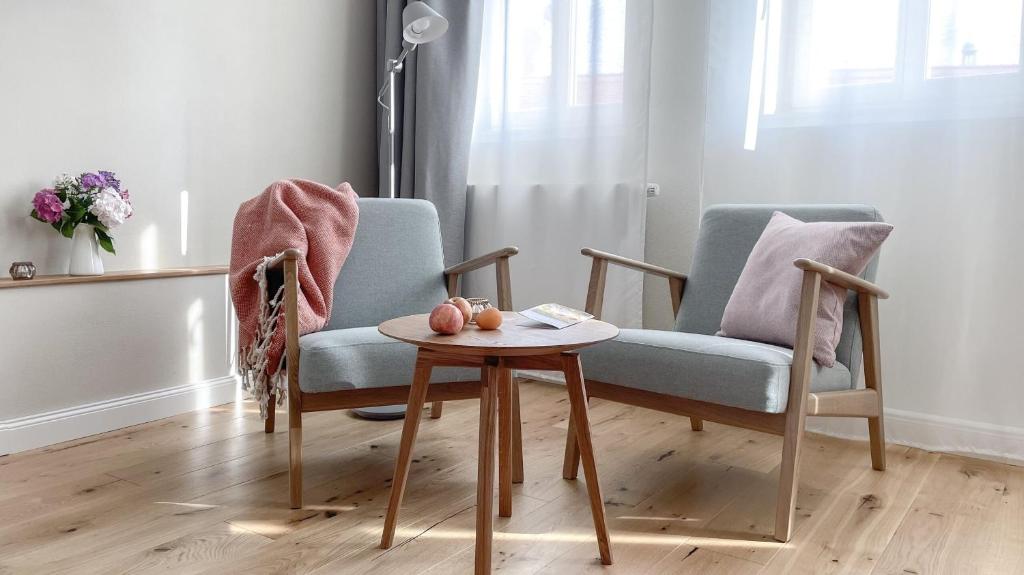 a living room with a chair and a table at Apartments am Dom in Naumburg