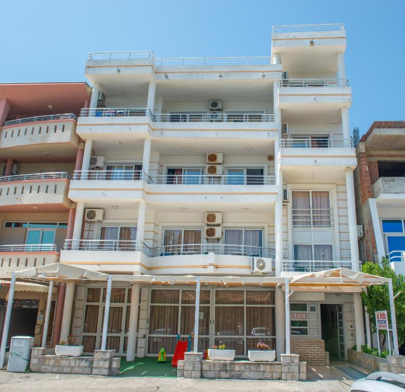 ein hohes weißes Gebäude mit vielen Fenstern in der Unterkunft Villa Fici in Ulcinj