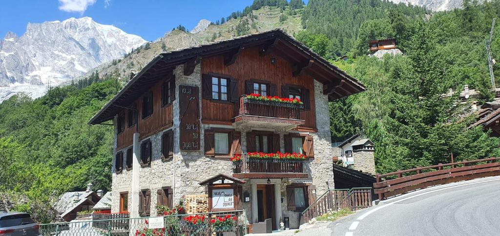 uma casa com flores ao lado de uma estrada em Hotel Dente Del Gigante em Courmayeur