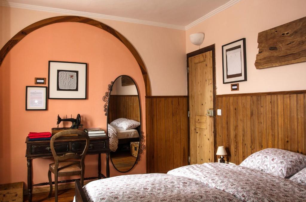 een slaapkamer met 2 bedden, een spiegel en een bureau bij Sintra Small Hostel in Sintra