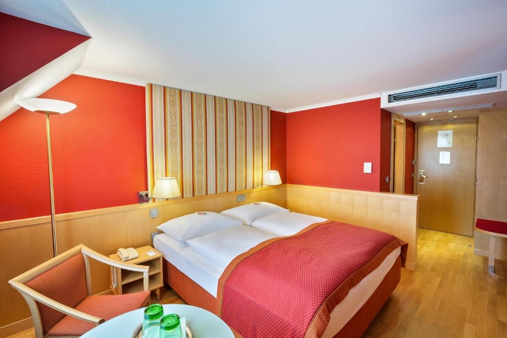 a hotel room with a large bed and a table at Austria Trend Hotel Ananas Wien in Vienna