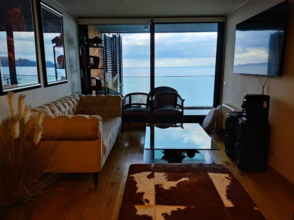 sala de estar con sofá y mesa en HOM I Hermoso Depto3D2B con parking vista al lago Pto Varas, Sin calefacción, en Puerto Varas