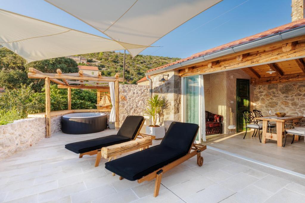 um pátio com 2 cadeiras e uma banheira de hidromassagem em Villa Teza Hvar em Hvar