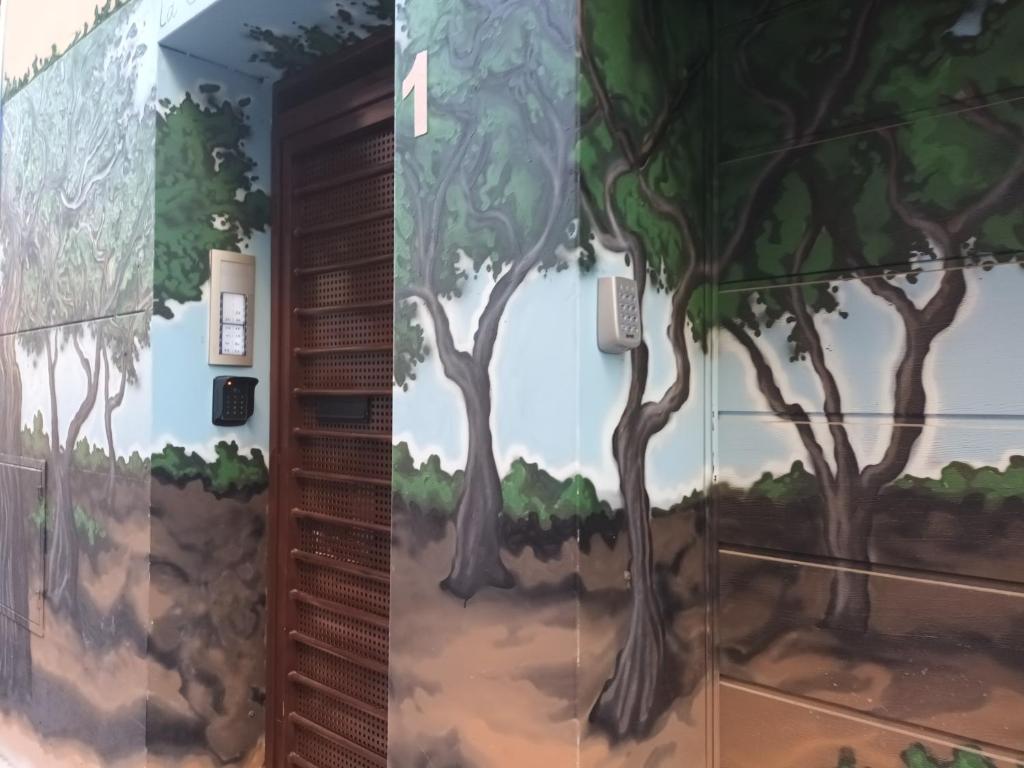 a mural of trees on the side of a building at La Casona del Eboni in Alcalá de Henares