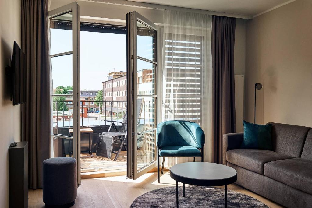 d'un salon avec un canapé et une vue sur un balcon. dans l'établissement Arbio I Makro Apartments, à Hambourg