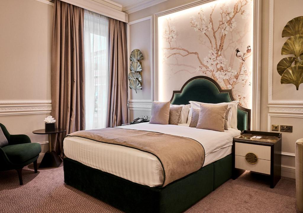 1 dormitorio con 1 cama grande y cabecero verde en Warren House Hotel, en Kingston upon Thames