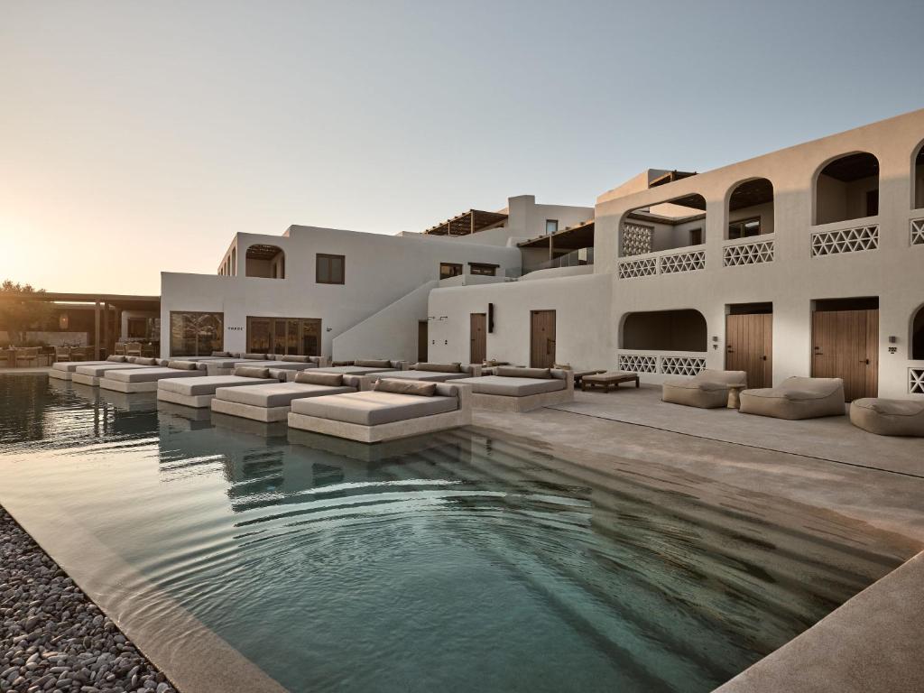 a house with a swimming pool in front of it at Domes Noruz Mykonos in Mýkonos City