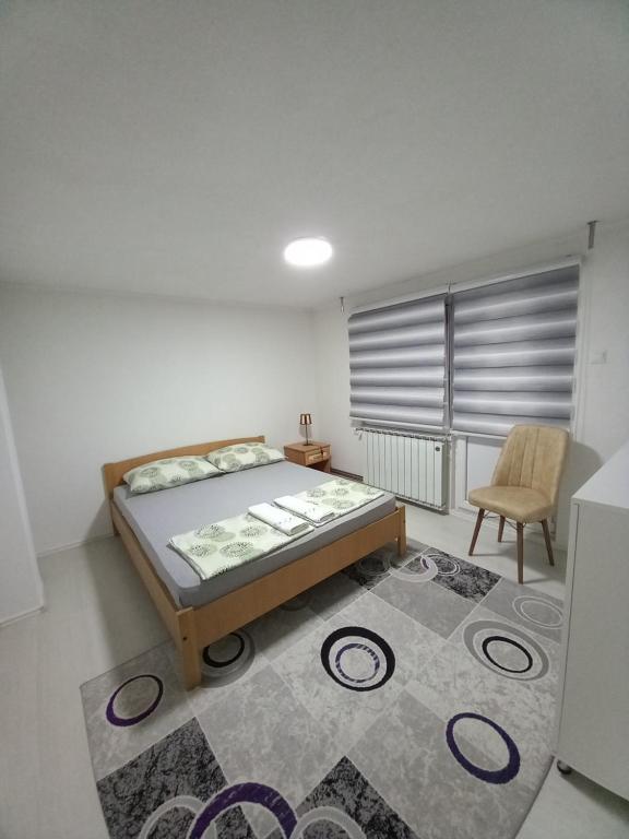 ein Schlafzimmer mit einem Bett, einem Stuhl und einem Teppich in der Unterkunft Apartment Maida in Dubrave Gornje