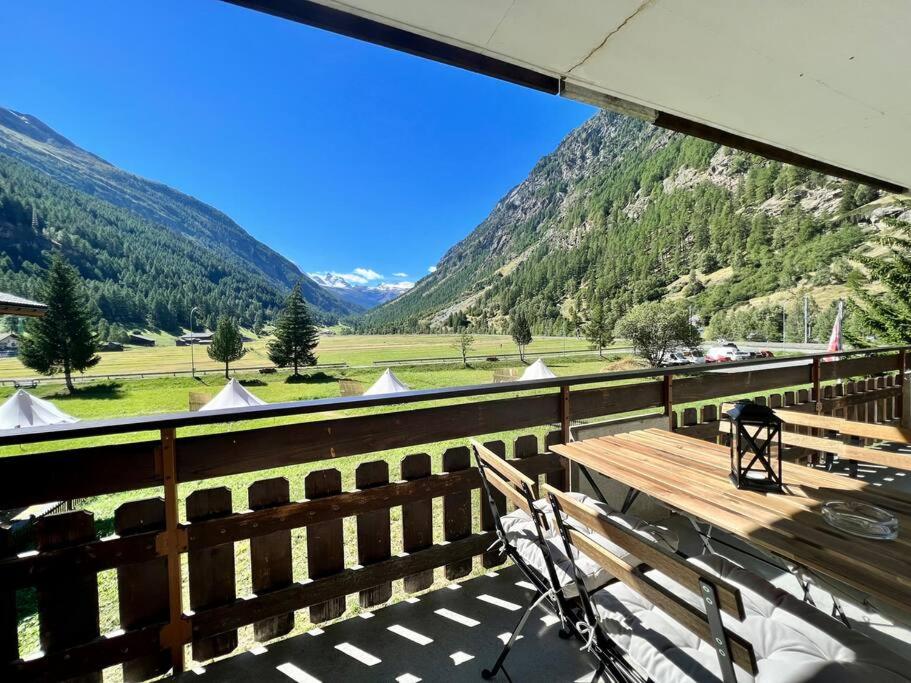 una panchina di legno su un balcone con vista sulle montagne di Mountain magic apartment for 6 Near Zermatt with parking! a Täsch