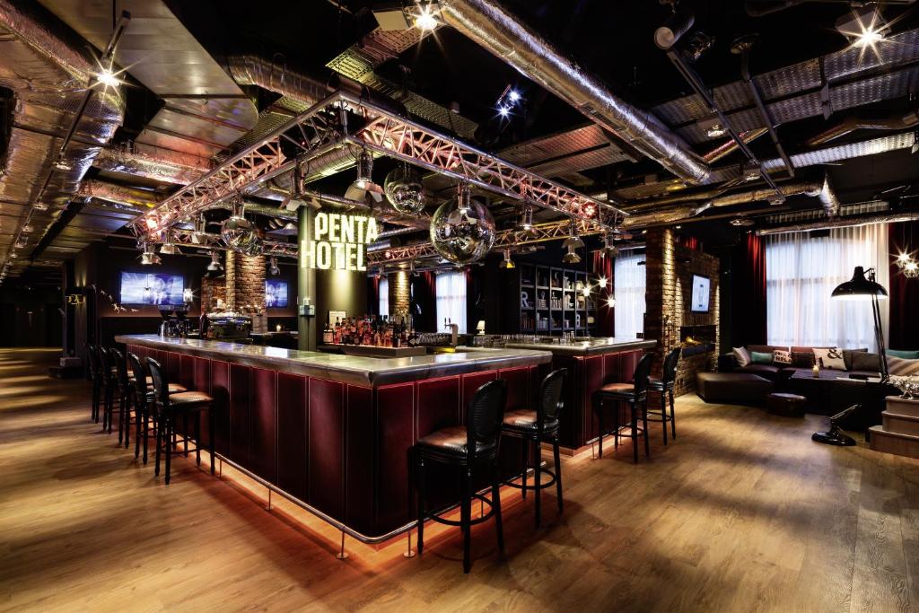 a bar in a room with chairs and a couch at pentahotel Paris Charles de Gaulle in Roissy-en-France