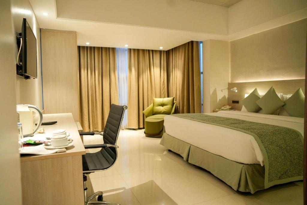 een hotelkamer met een groot bed en een bureau bij Lakeshore Heights in Dhaka