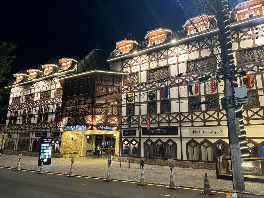 a large building on a city street at night at Center Suiço Flats in Campos do Jordão