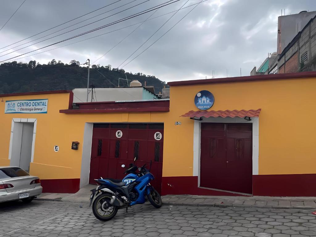 uma moto azul estacionada em frente a um edifício em Casa Julia Xela em Quetzaltenango