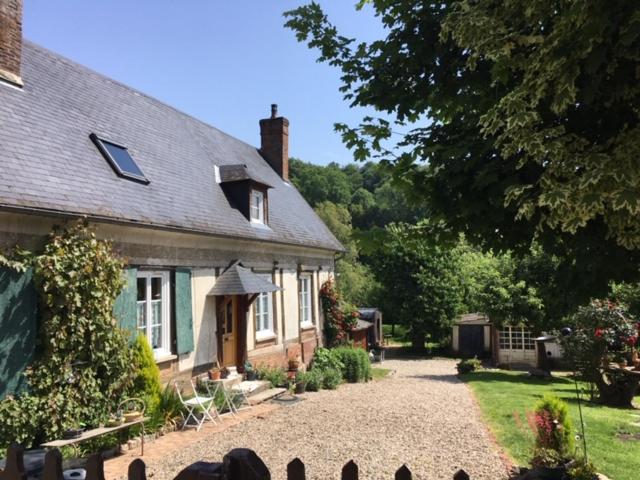 una casa con una entrada de grava delante de ella en Appart dans longère Normande au coeur de la Forêt de Lyons, 