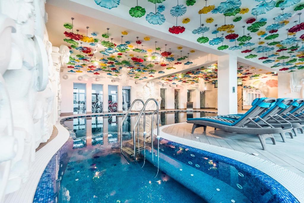 a pool in a hotel with a ceiling filled with flowers at Villa Galleria in Colibiţa