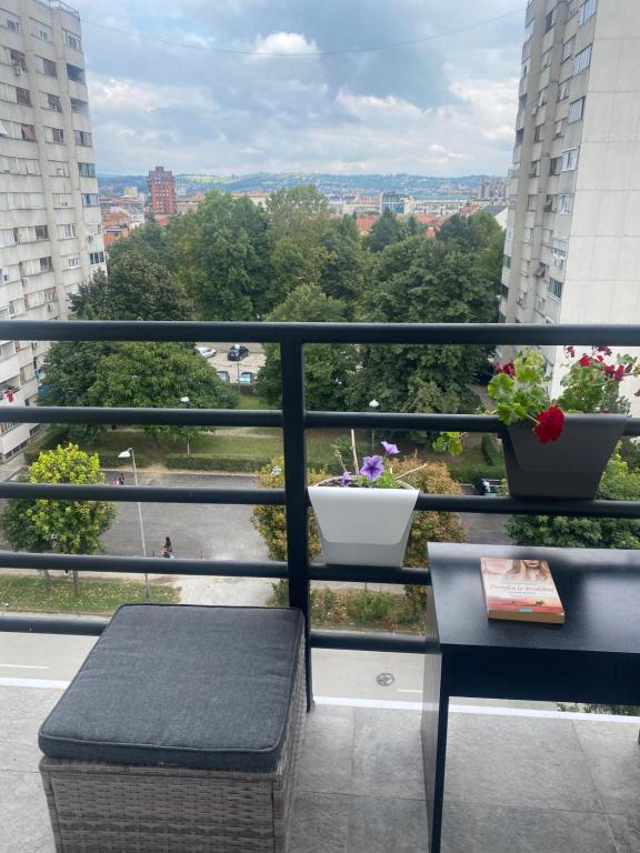 a balcony with a bench and a view of a city at Apartman Una in Čačak