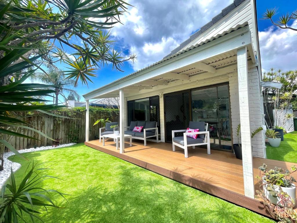 una terrazza con sedie e tavoli su un prato di Seabreeze Villa on Mermaid Beach/ Broadbeach a Gold Coast