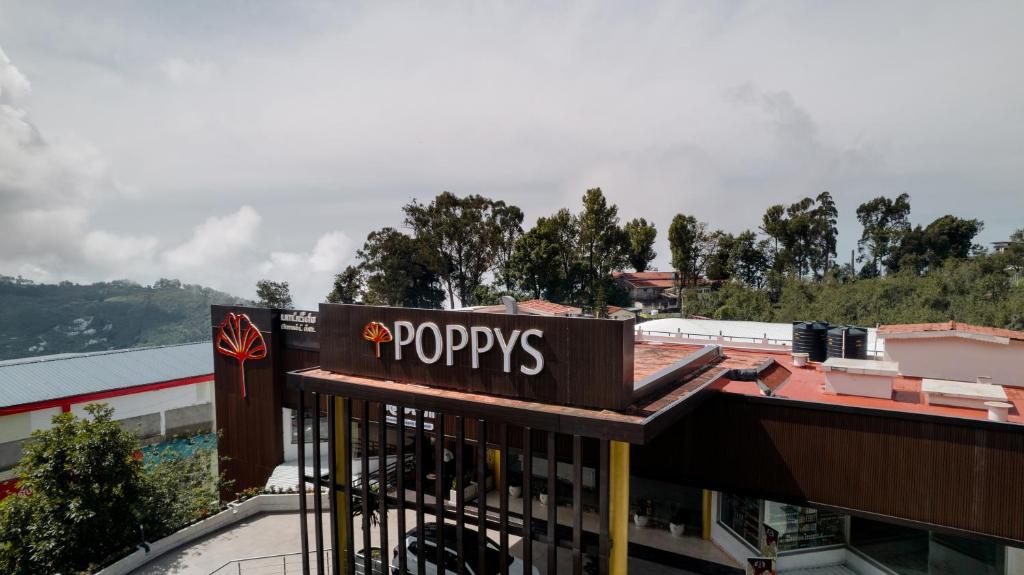 コダイカナルにあるPoppys Pleasant Stayの建物上の看板