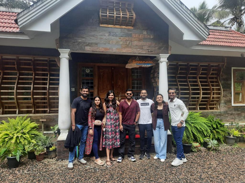 a group of people standing in front of a house at Sopanam Heritage Thekkady in Thekkady