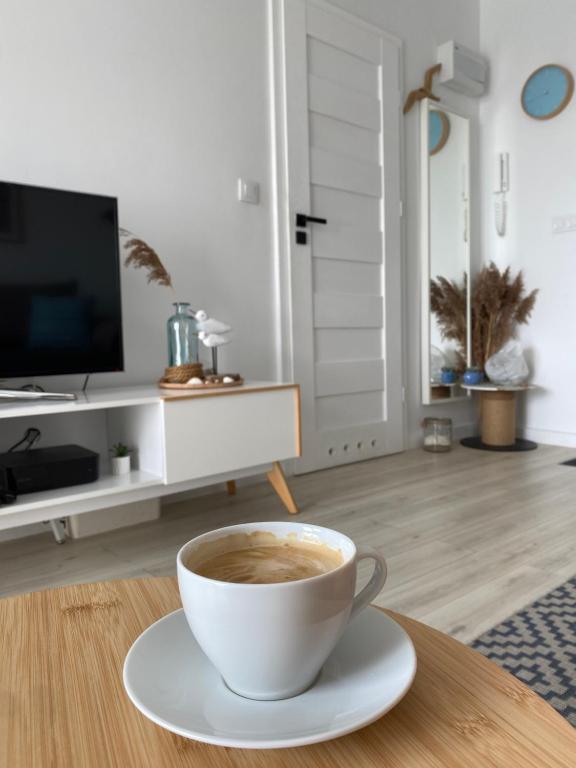 una tazza di caffè sul tavolo in soggiorno di Apartament Horizon a Gdynia