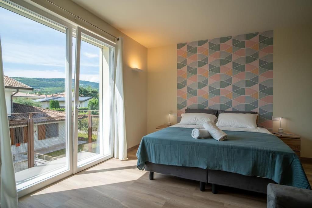 a bedroom with a bed and a large window at Monolocale Moderno Valpolicella Verona - Agni in San Pietro in Cariano