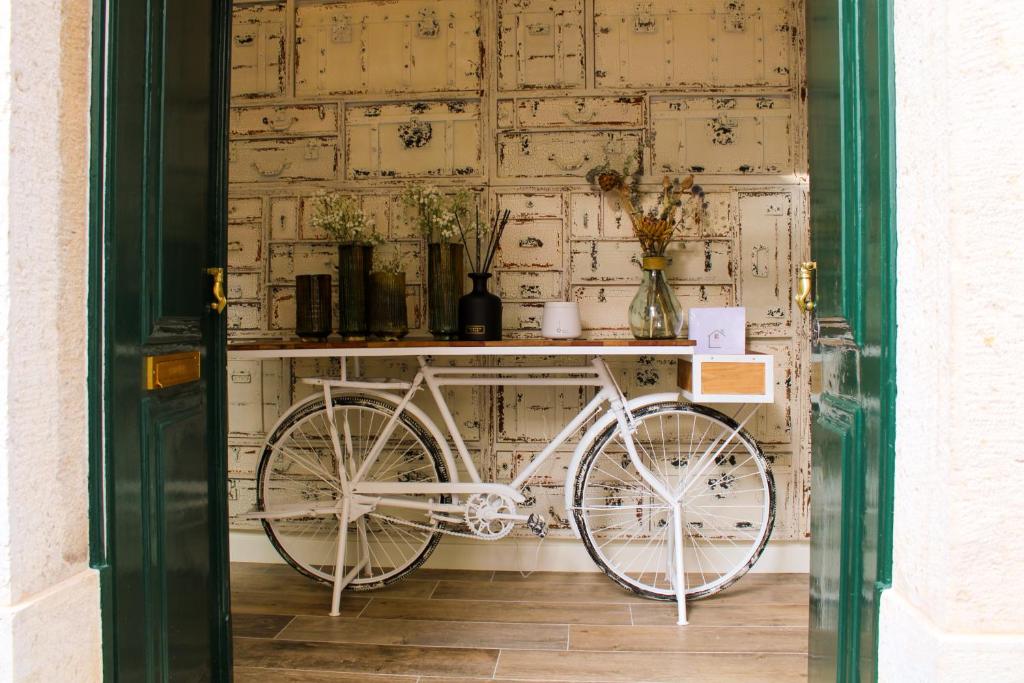 een witte fiets geparkeerd voor een muur bij Casa dos Cucos in Ericeira