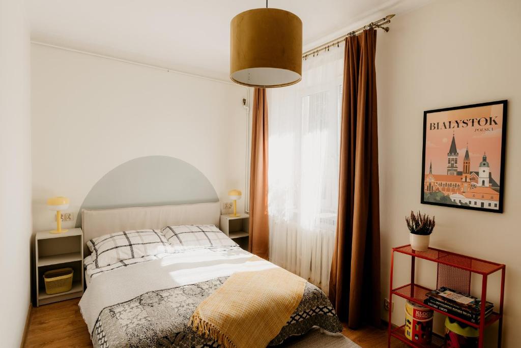 a bedroom with a bed and a large window at Flathouse Apartment 2 Centrum in Białystok