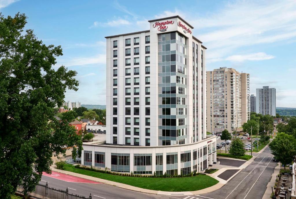 a tall white building with a sign on top of it at Hampton Inn By Hilton Hamilton in Hamilton