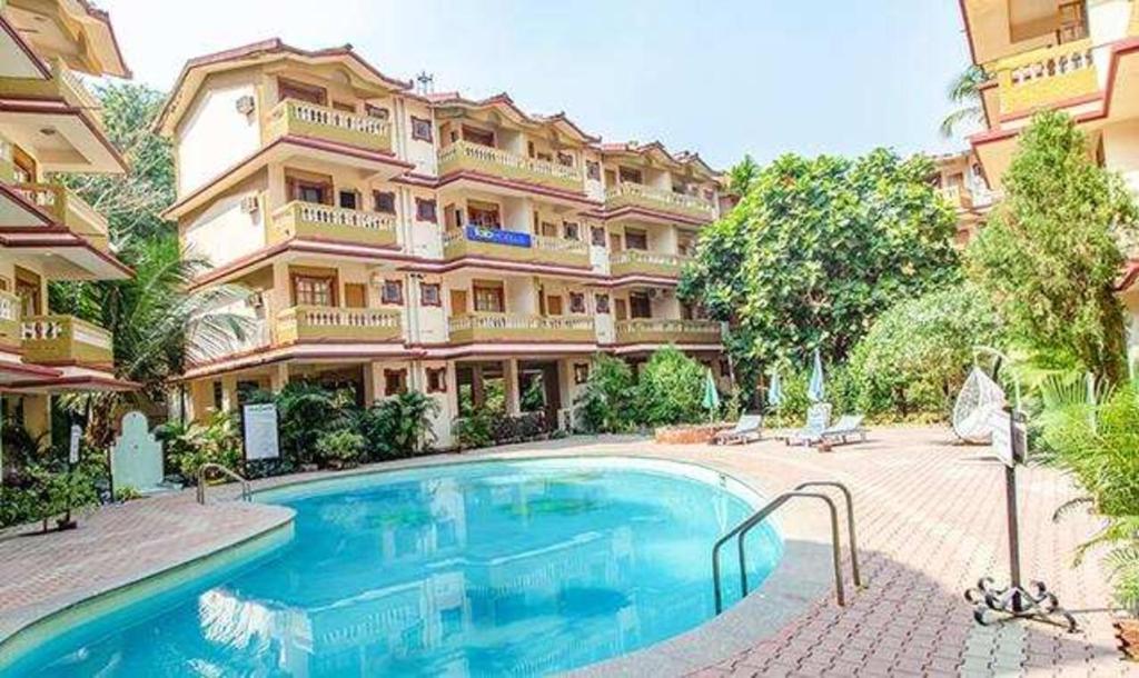 um grande edifício com uma piscina em frente em FabHotel Prime Toro Highland Beach Resort With Pool - Nr Candolim Beach em Candolim