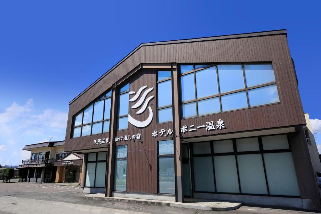 een gebouw met een bord aan de zijkant bij Hotel Pony Onsen in Towada