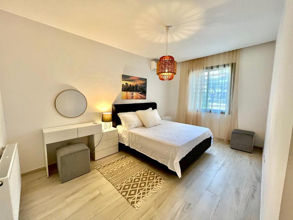 a bedroom with a bed and a table and a mirror at "Luxe Residence" Marsa avec Parking in Tunis