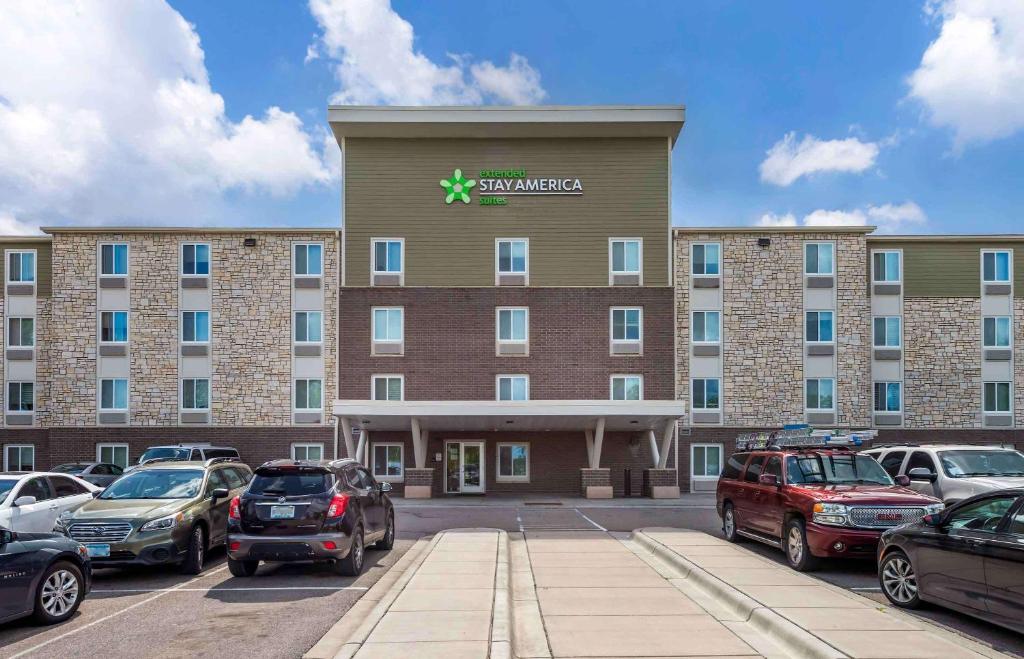 un grand bâtiment avec des voitures garées dans un parking dans l'établissement Extended Stay America Suites - St Paul - Woodbury, à Woodbury