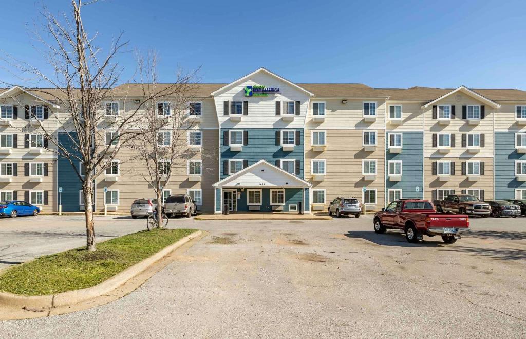 een groot gebouw met een rode truck er voor geparkeerd bij Extended Stay America Select Suites - Fayetteville - I-49 in Fayetteville