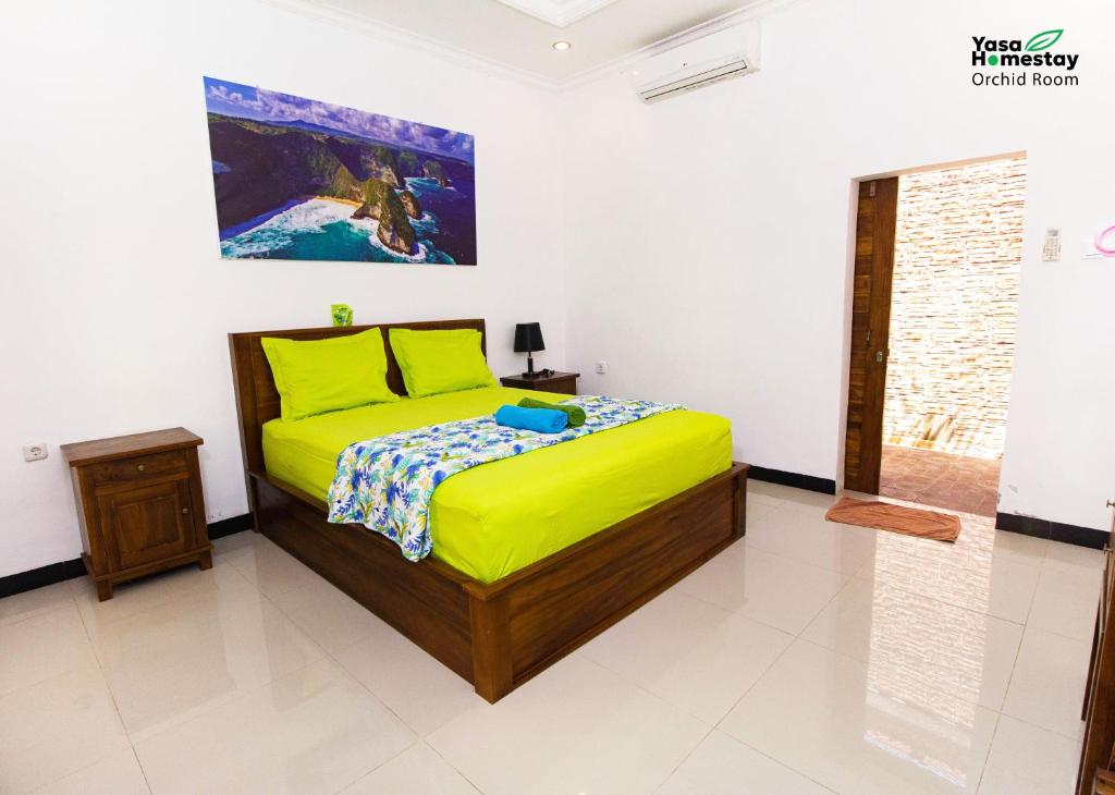 um quarto com uma cama e um quadro na parede em Yasa Homestay em Nusa Penida