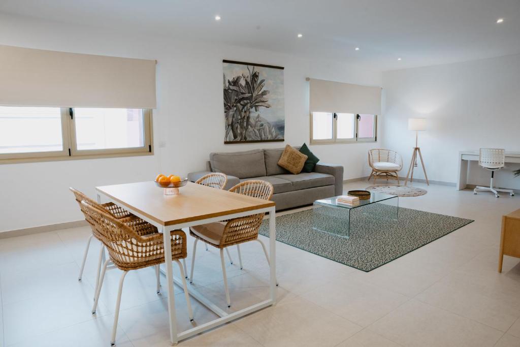 uma sala de estar com uma mesa e um sofá em Las Canteras Beach Suites em Las Palmas de Gran Canárias