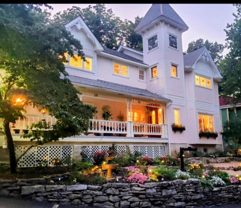 a large white house with a clock on it at Inn at Rose Hall in Eureka Springs