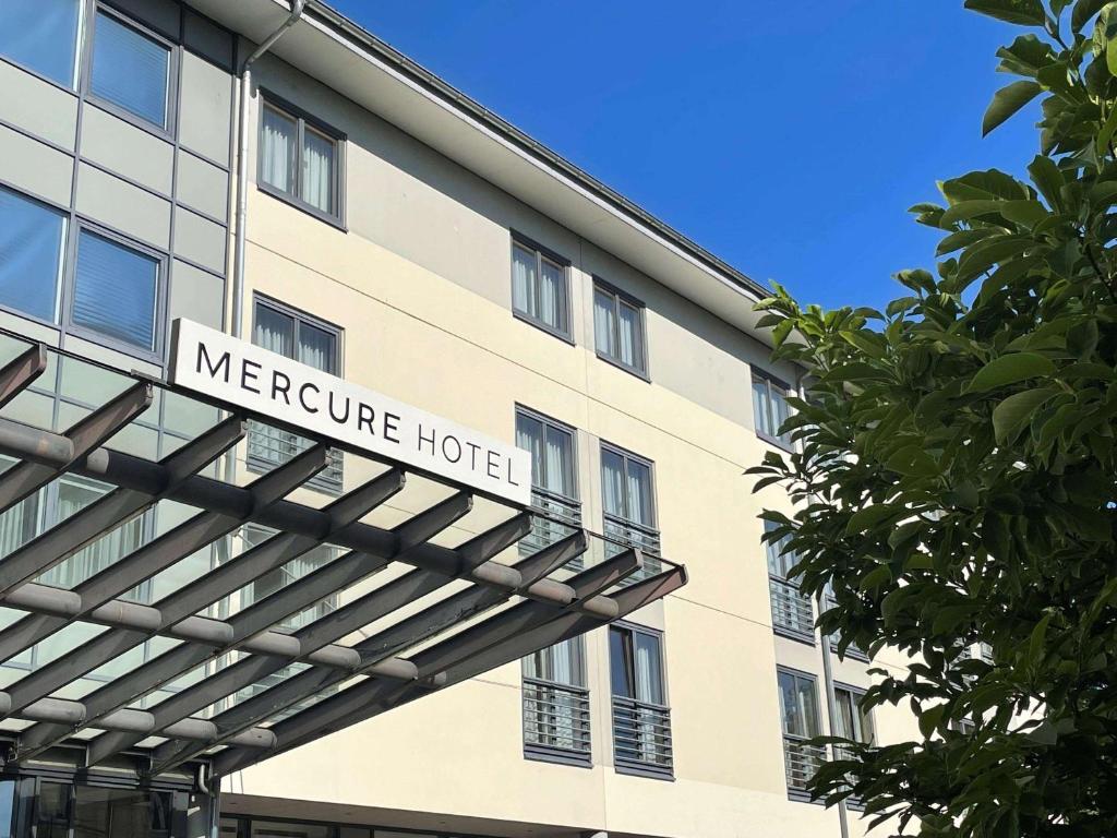 un bâtiment avec un panneau indiquant l'hôtel mercure dans l'établissement Mercure Hotel Gera City, à Gera