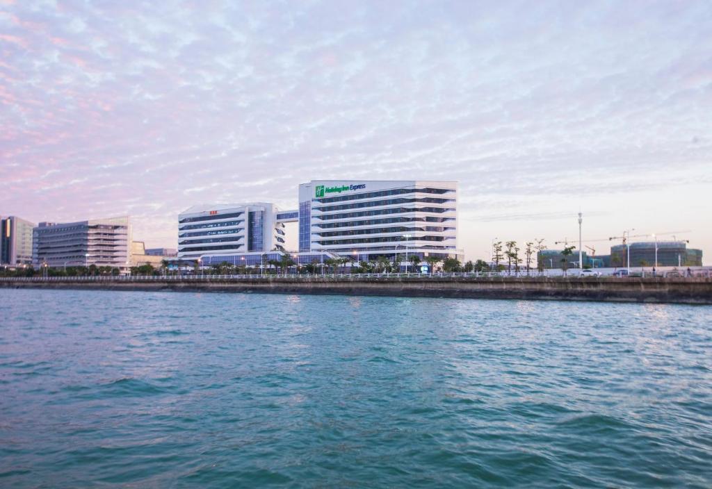 einen Blick auf eine Stadt aus einem Wasserkörper in der Unterkunft Holiday Inn Express Xiamen Airport Zone, an IHG Hotel in Xiamen