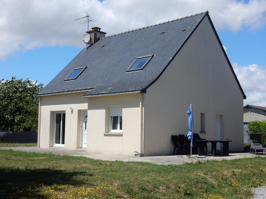 uma casa branca com um telhado preto em Maison 3 chambres 120m2 3km ploermel em Ploërmel