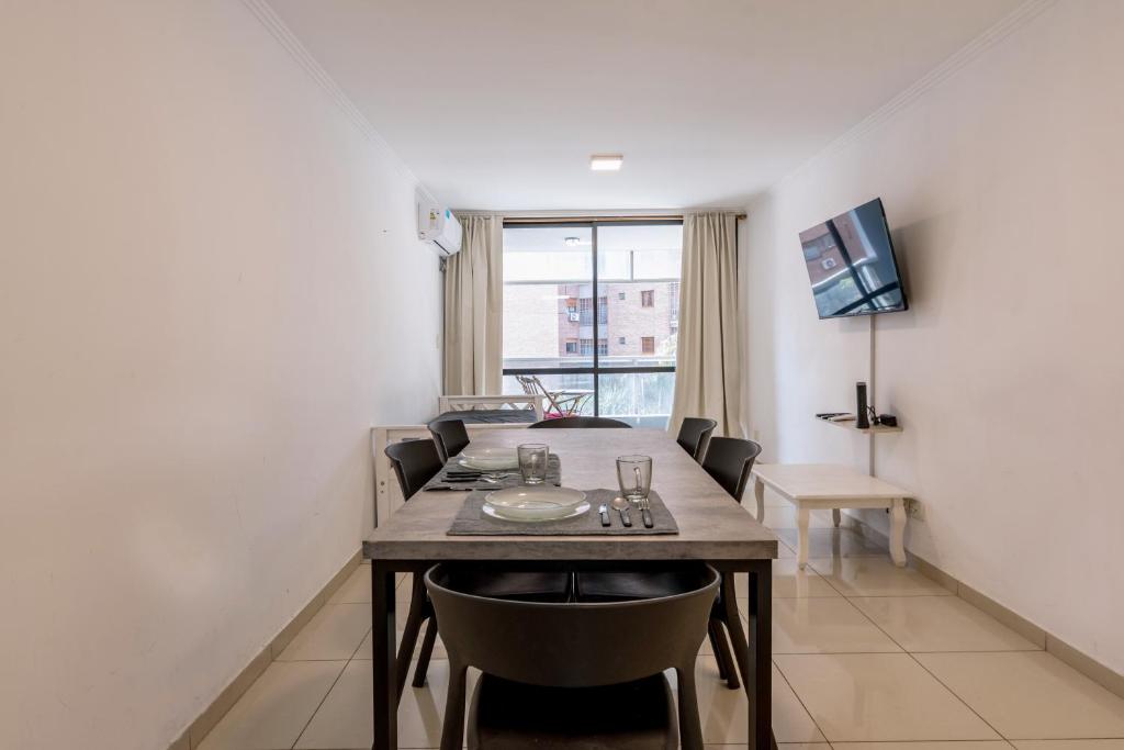 - une table à manger et des chaises dans une pièce avec fenêtre dans l'établissement Cómodo depto de dos habitaciones by lofty, à Córdoba